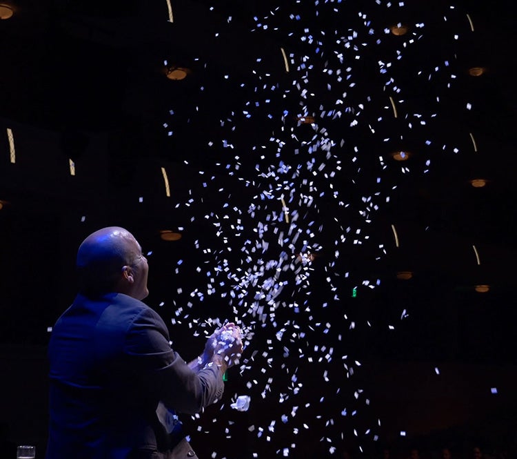 Bill Blagg dressed in dark colors surrounded by confetti